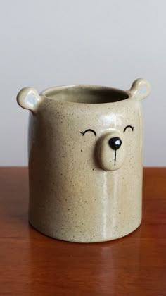 a ceramic bear mug sitting on top of a wooden table