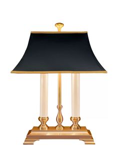 a lamp that is on top of a stand with a black lampshade over it