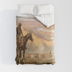 a bed with a painting on it and a man riding a horse in the background