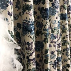 the curtains are decorated with blue flowers and white feathers