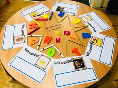 a wooden table topped with lots of different types of magnets and writing on it