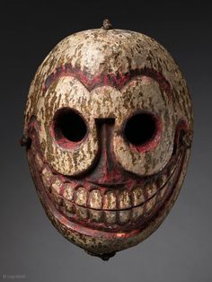 an old mask with two eyes and a smile