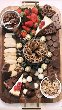 a wooden platter filled with lots of different types of desserts and pastries