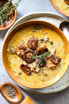 a bowl of soup with mushrooms and herbs