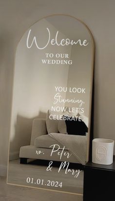 a mirror with the words welcome to our wedding written on it in front of a couch