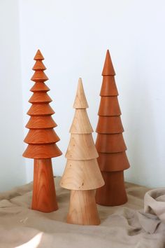 three wooden christmas trees sitting on top of a table