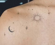 the back of a man's shoulder with stars and moon tattoos on it