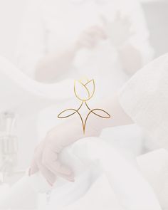 a woman's hand with a gold flower on it and the words lotus above her