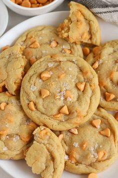 a white plate topped with cookies next to bowls of nuts