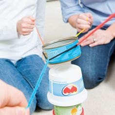 two people are sitting on the floor playing with some sort of thing in their hands