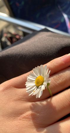 a woman's hand with a daisy ring on it