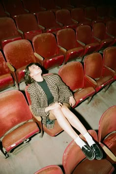 a woman sitting in an empty theater seat