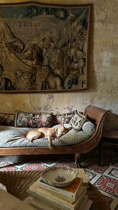 a dog laying on top of a bed next to a wall hanging over it's head