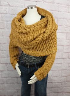 a mannequin wearing a yellow knitted scarf on top of a white brick wall