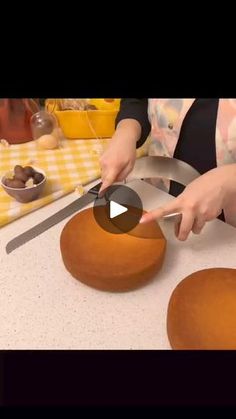 a woman is using a knife to cut some cake