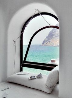 an image of a window that is open to the ocean and has some books on it