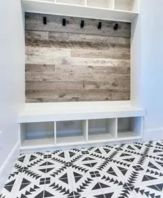 an empty room with white shelves and black and white tiles