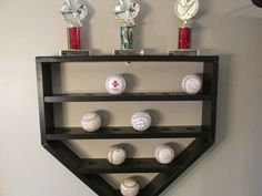 a shelf with baseballs and trophies on it in the shape of a heart shaped triangle