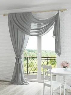 a white table and chair in front of a window with blue drapes on it