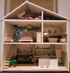 a doll house is shown with furniture and accessories in the front, stairs to the second floor