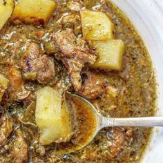 a white bowl filled with meat and potatoes