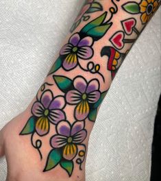 a person's foot with flowers and hearts on it