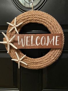 a welcome sign hanging on a door with starfishs attached to the front and side