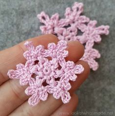 small crochet snowflakes are being held in someone's hand,