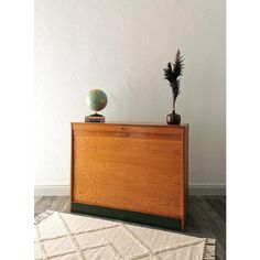 a wooden cabinet with a plant on top