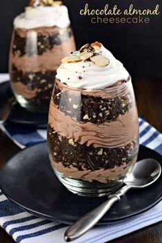 chocolate almond cheesecake trifle with whipped cream and cookies in glasses on a black plate