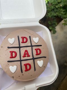 a cake in a box with the words dad written on it and hearts cut out