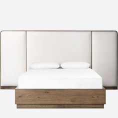 the bed is made with white sheets and pillows on it's headboard, along with two nightstands