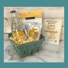 a basket filled with snacks and drinks next to a book