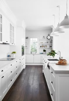 a kitchen with white cabinets and wood flooring is featured in the may issue of architectural digest