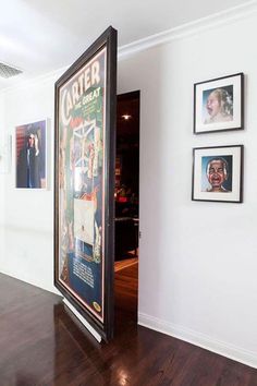 an open door leading into a room with pictures on the wall and wood floors in front of it