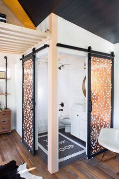 a bathroom with an open shower and wooden flooring, white walls and black ceiling