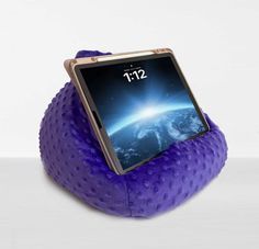 an ipad is sitting on top of a purple pillow that's shaped like a turtle