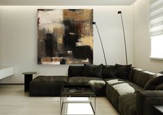 a living room filled with furniture and a large painting on the wall above it's windows