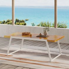 a wooden table sitting on top of a hard wood floor next to an open window