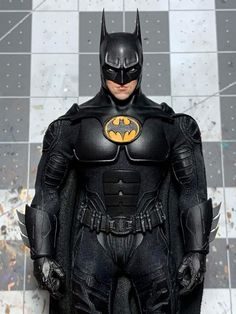 the dark knight batman action figure is standing in front of a tiled wall and floor