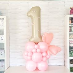 a number one balloon in the shape of balloons on a shelf next to a bookcase