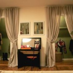 a bedroom with curtains and a desk in the corner