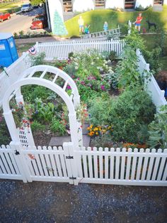 an aerial view of a garden with white fences