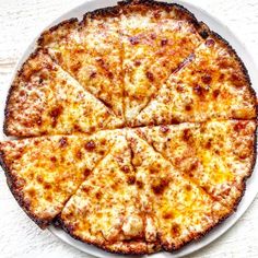 a cheese pizza cut into eight slices on a white plate