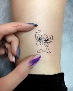 a woman's leg with a small tattoo on the side of her body, which has an image of a cartoon character drawn on it