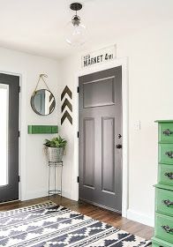 a black and white area rug in front of a door with green accents on it