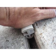 a man's hand is holding the end of a piece of concrete