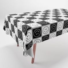 a black and white table cloth with smiley faces on it, sitting in front of a white background