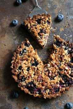 two pieces of blueberry crumb pie on a table