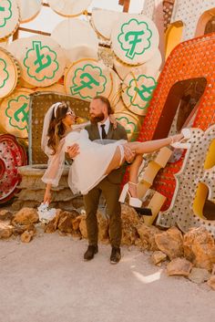 a bride and groom holding each other in front of a large sign with dollar signs on it